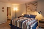 The master bedroom is spacious with a queen size bed and classic furnishings